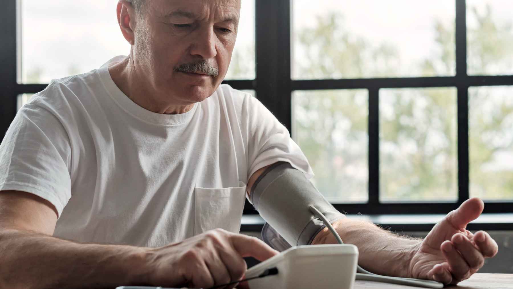 Person checking blood pressure at home with a digital monitor