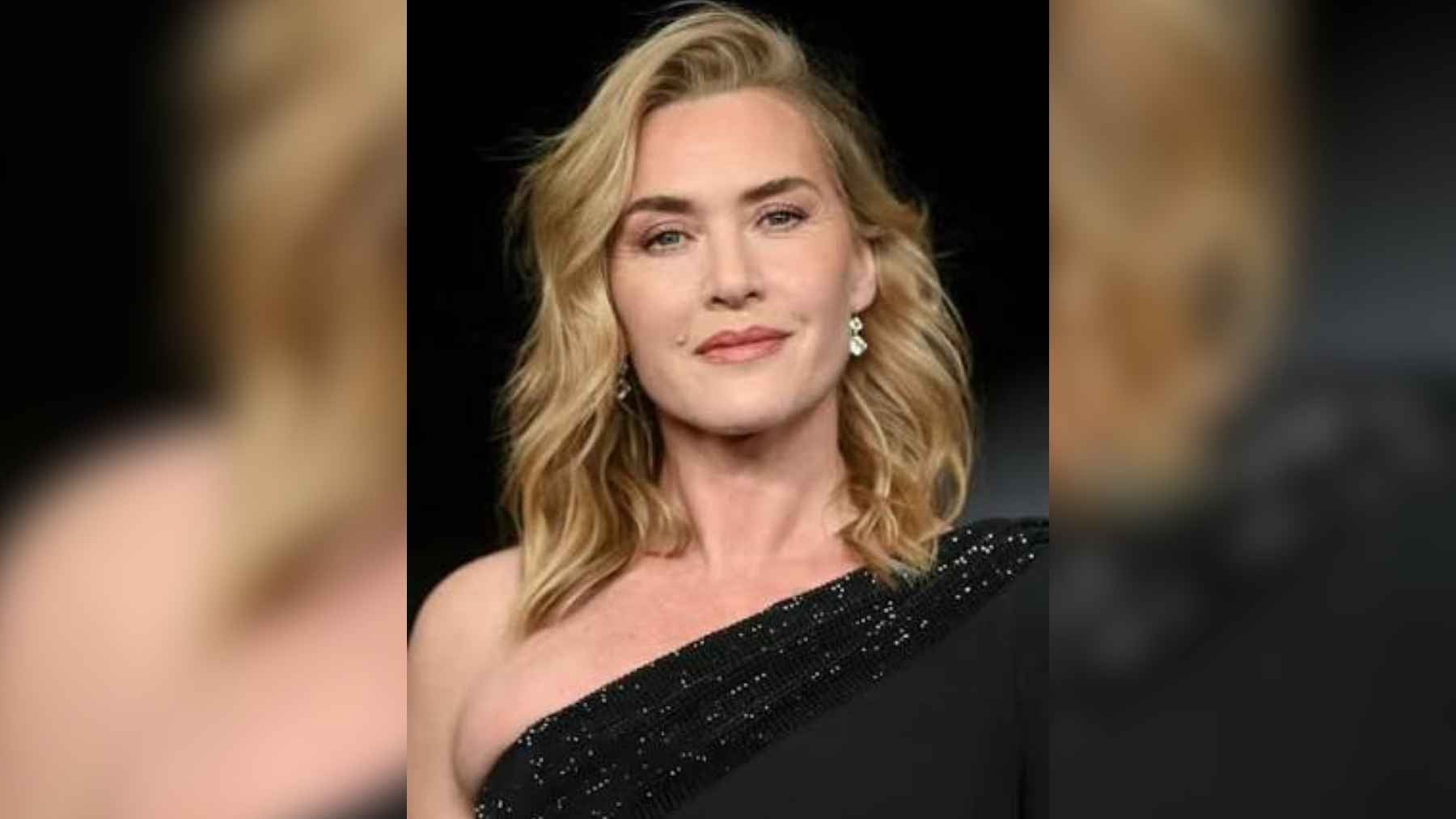 Actress Kate Winslet speaking at a podium while accepting an award with deep emotion.