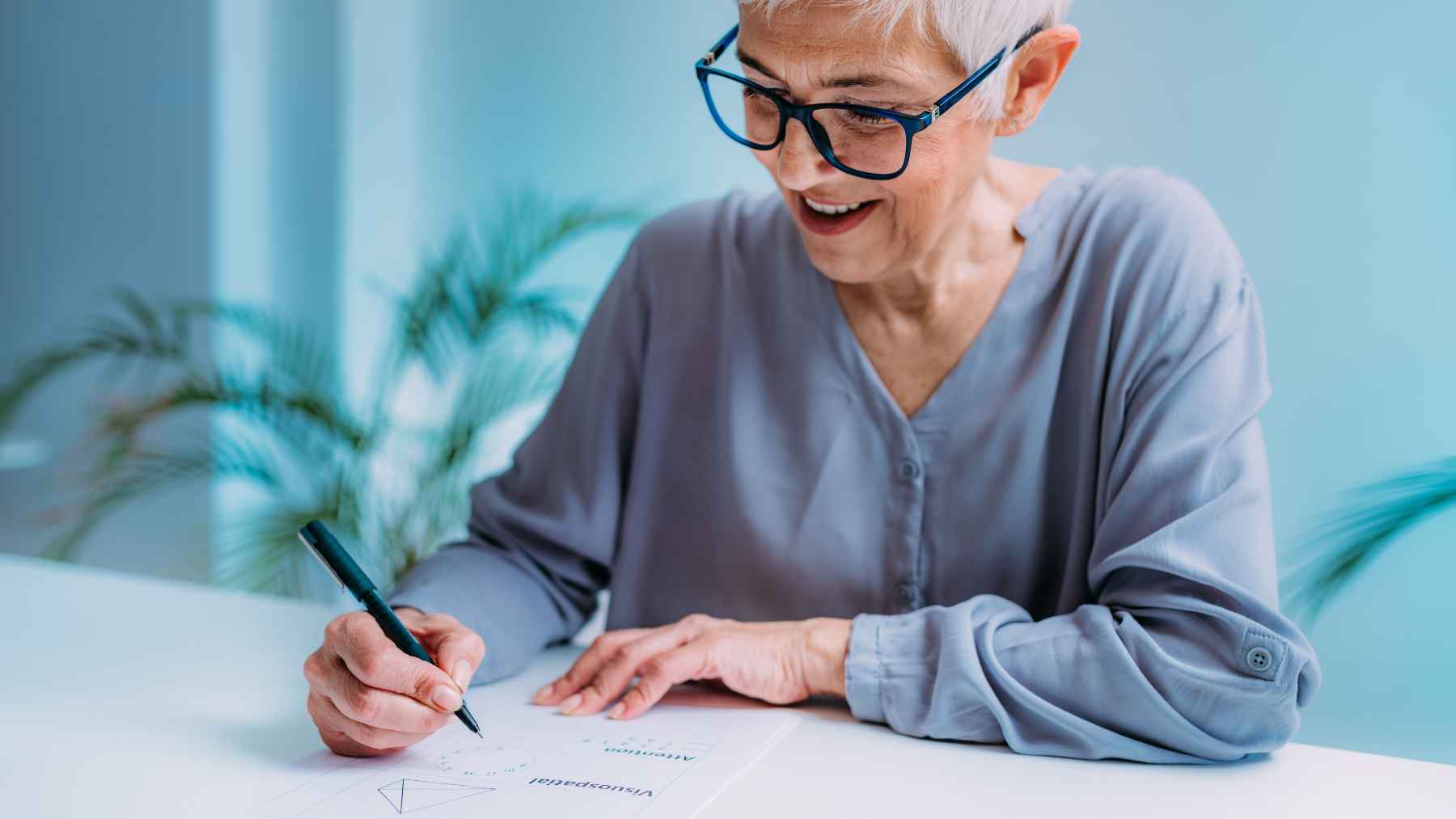 Older woman writing at a desk, representing older adults imagining new futures and staying engaged later in life