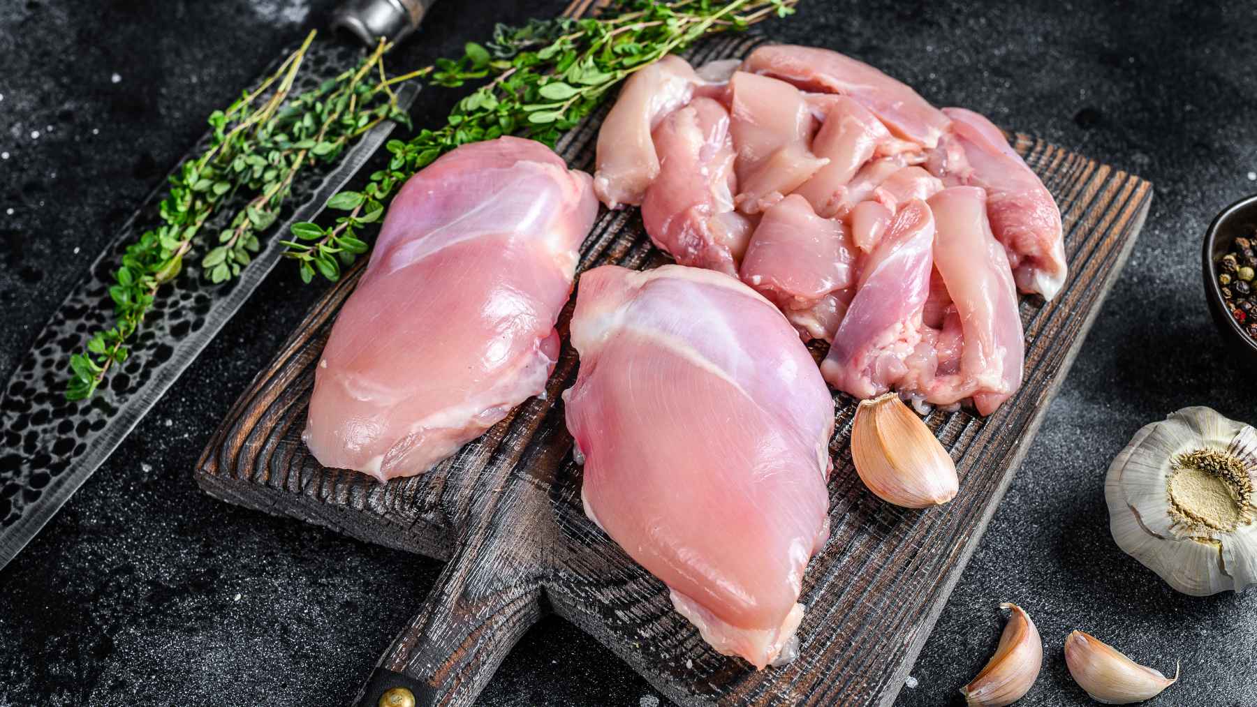 A portion of cooked chicken breast on a plate with fresh vegetables to illustrate daily protein tracking.