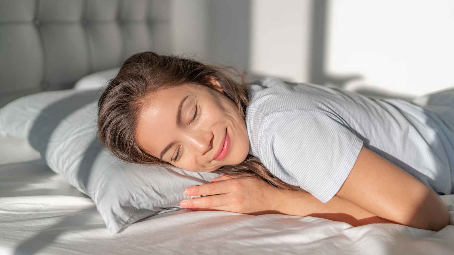 Woman sleeping peacefully in bed, illustrating the popular claim that rosemary in the bedroom may promote relaxation and improve sleep