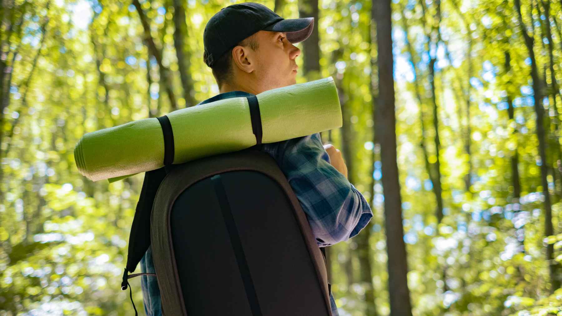 Person wearing a weighted backpack while walking outdoors during a rucking workout