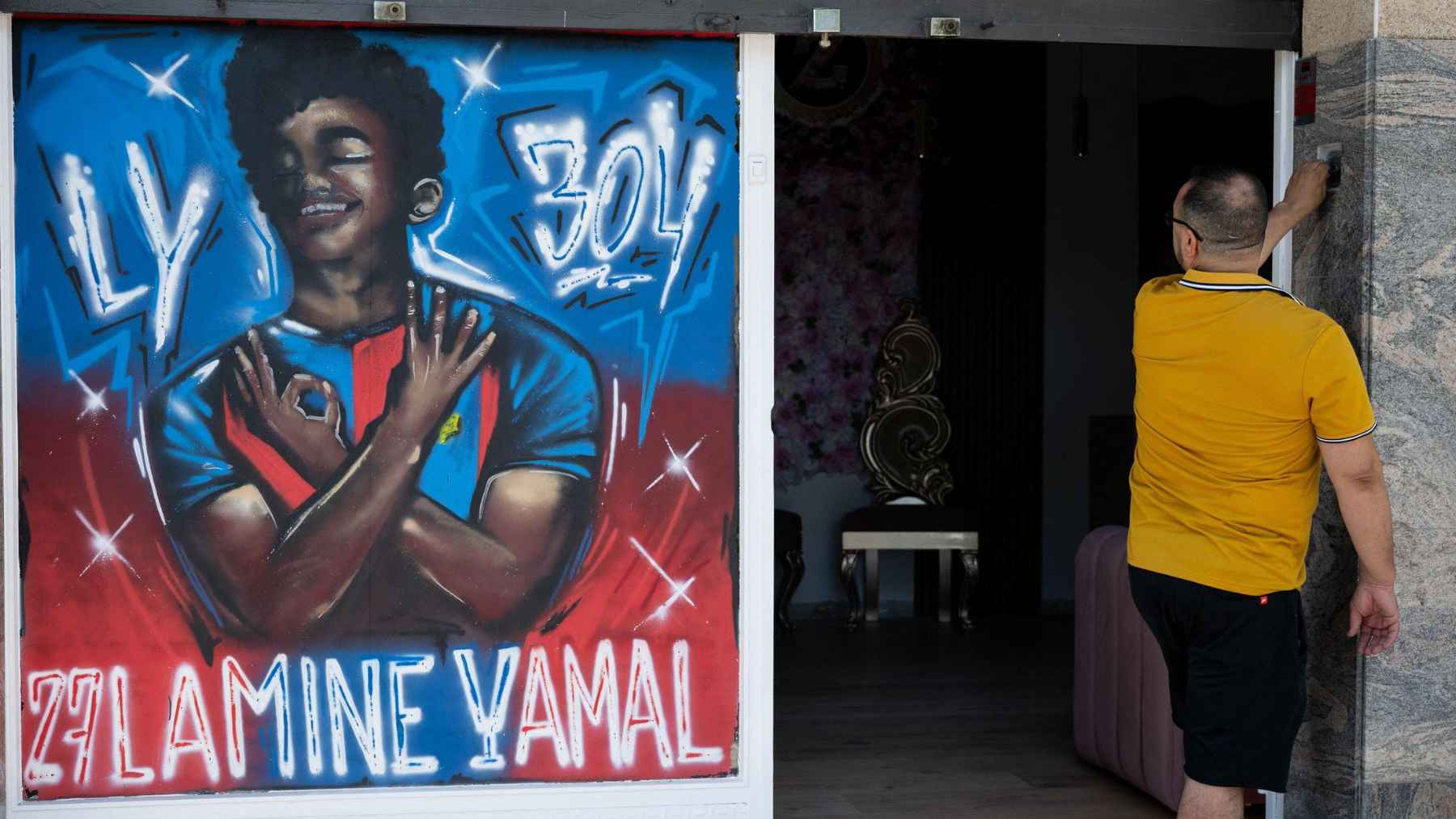 Mural of a young soccer player with the number 304 painted on a storefront in Rocafonda