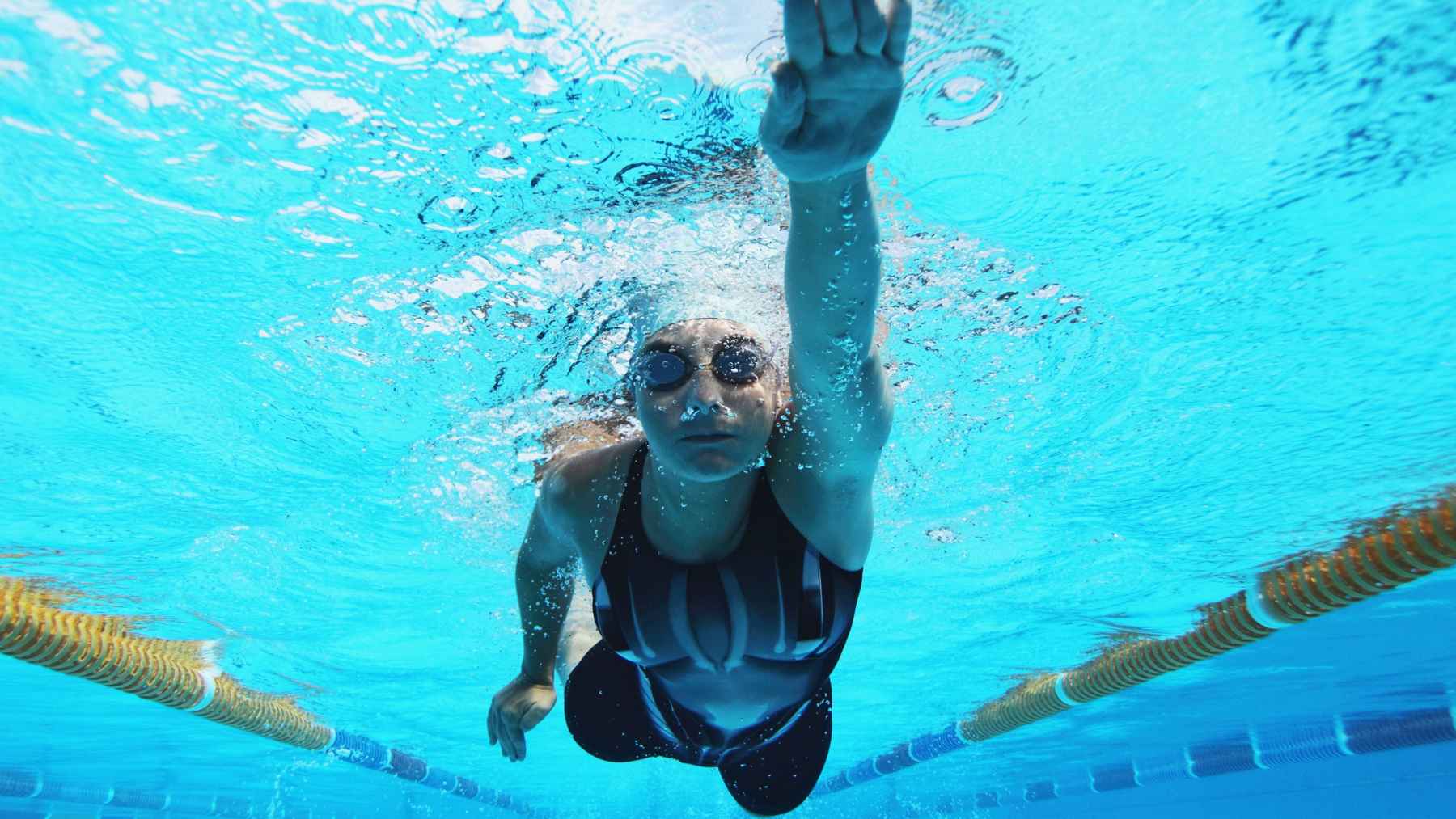 Man swimming laps in a pool as a full-body exercise that works the heart, lungs, arms, legs, shoulders and core while reducing joint impact