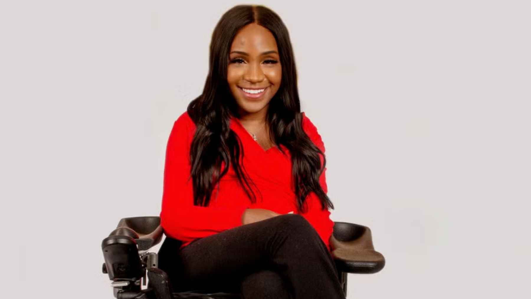 Taylor Lindsay-Noel smiling as an entrepreneur and accessibility advocate in her wheelchair.