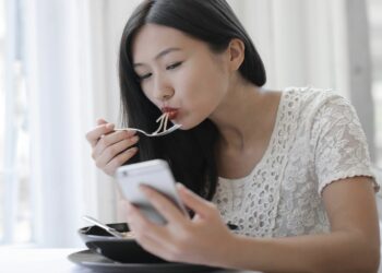 Mujer comiendo, móvil
