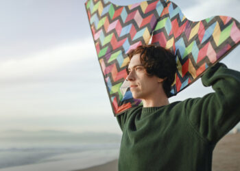 hombre con barrilete, personas mentalmente fuertes, mar, horizonte, mirada