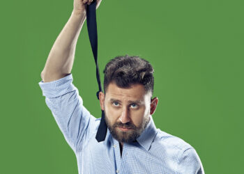 Hombre empresario, de camisa, sacándose la corbata, formal