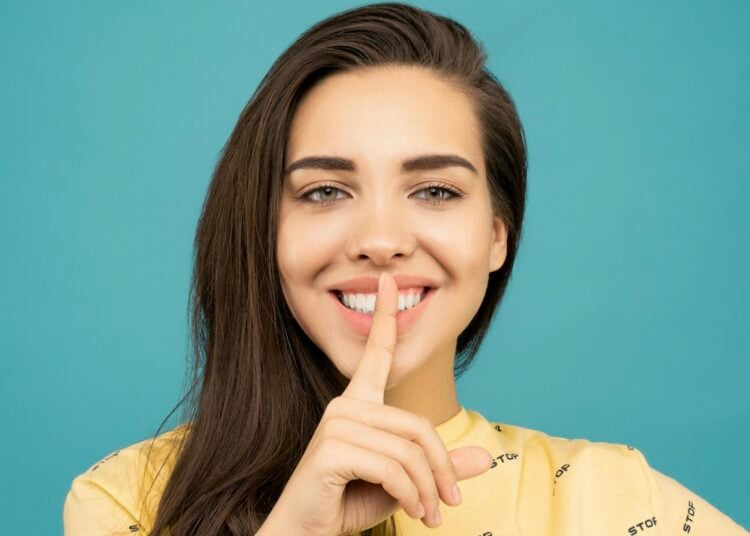 Mujer sonriendo, silencio, secreto, tono de voz