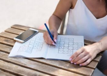 Persona resolviendo sudokus.