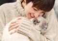 Mujer joven abraza un gato blanco. (Foto: Freepik)
