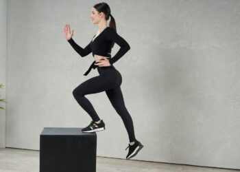 Joven mujer haciendo gimnasia con un cajón pliométrico. Foto : Freepik