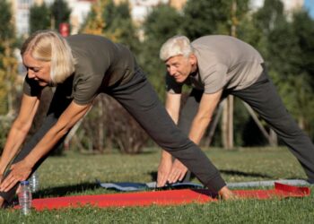 Pareja mayor practicando ejercicio suave al aire libre. Foto: Freepik