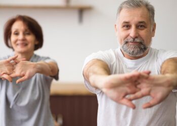 Pareja practicando ejercicio de pilates en casa. Foto: Freepik