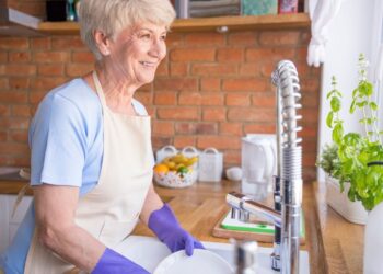 Una jubilada limpia su cocina. Foto: Freepik