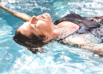 Una mujer practica ejercicios de relajación en una piscina. Foto: Freepik - rawpixel.com