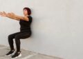 Una mujer adulta haciendo el ejercicio de sentadilla de pared. Foto: Freepik