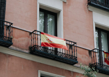 Personas que cuelgan la bandera de España en su balcón