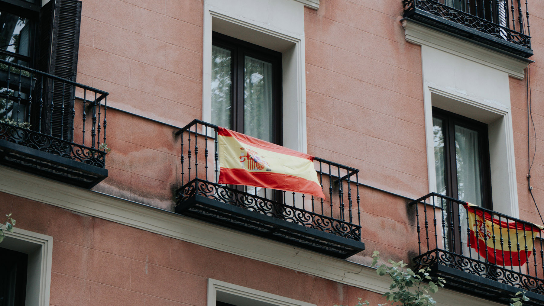 Personas que cuelgan la bandera de España en su balcón