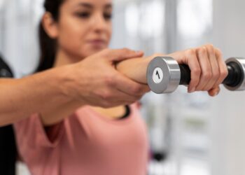 Mujer haciendo ejercicio con pesas. Foto: Magnific