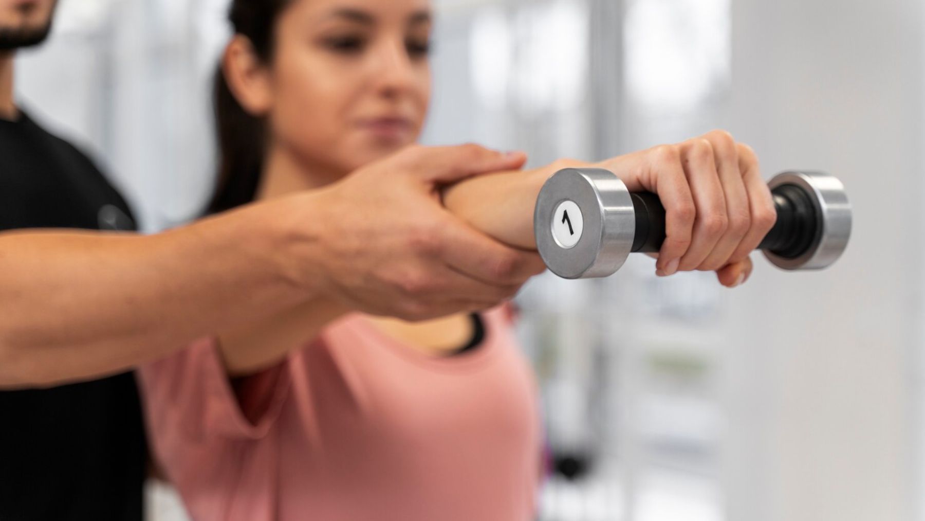 Mujer haciendo ejercicio con pesas. Foto: Magnific