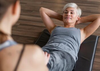 Una mujer senior haciendo abdominales. Foto: Freepik