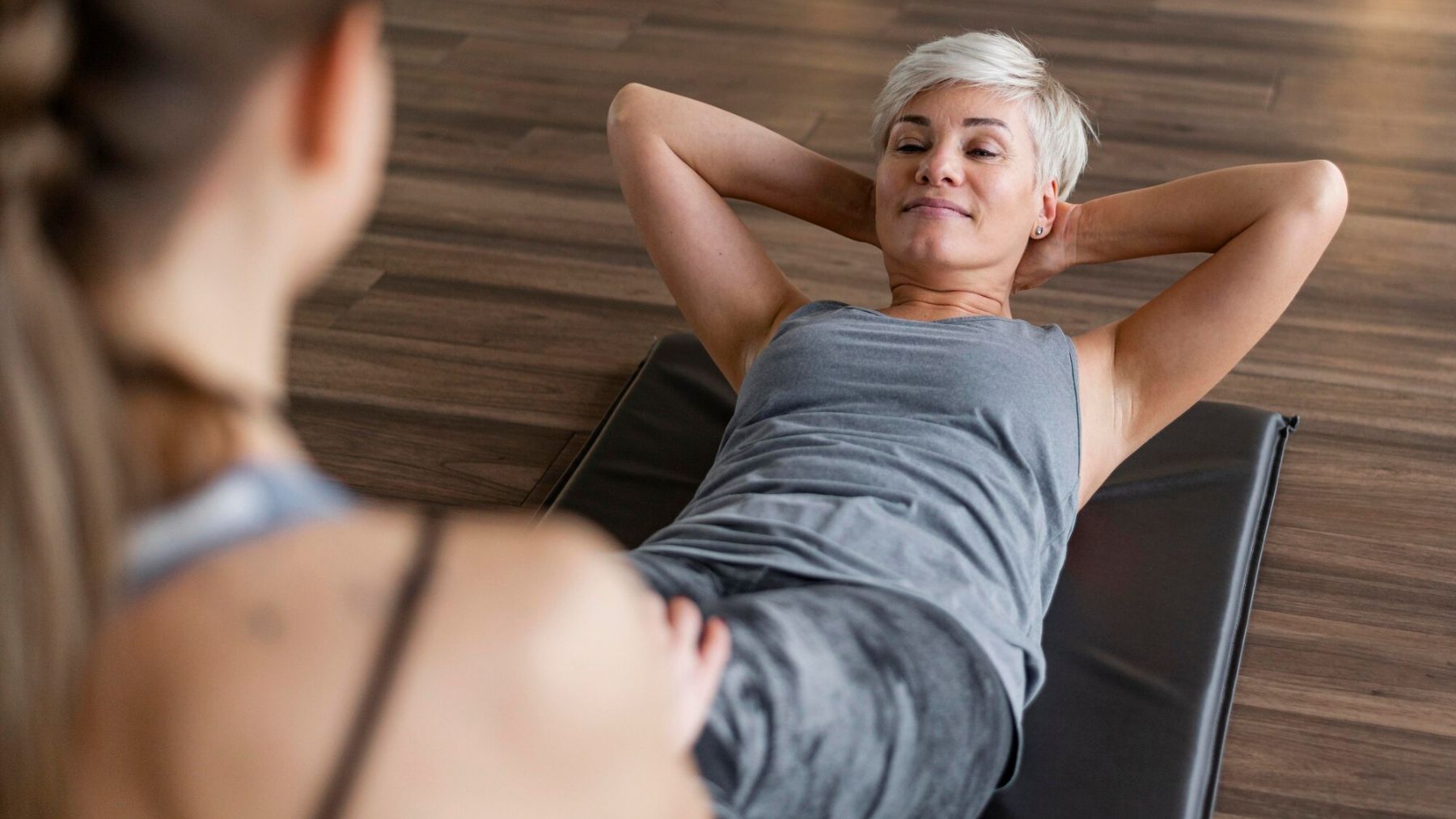 Una mujer senior haciendo abdominales. Foto: Freepik
