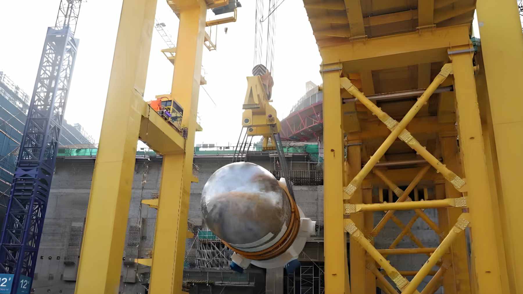 A massive 288-ton steel containment dome being hoisted by cranes at the Lufeng nuclear power plant in China.