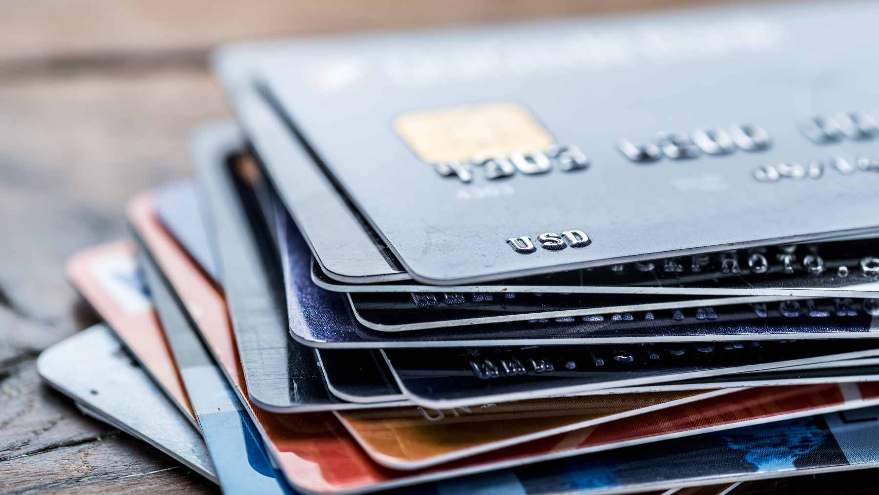 A close-up of a person wrapping a contactless credit card in a layer of aluminum foil to create a makeshift Faraday cage.