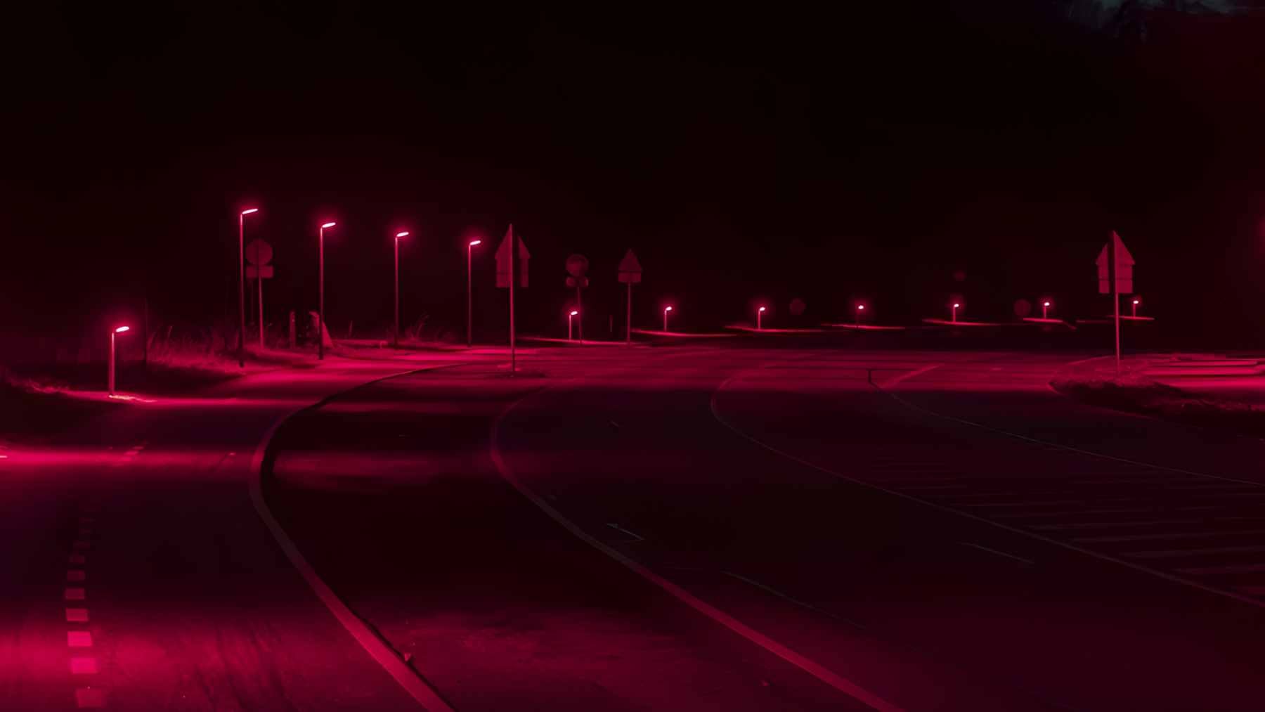 A long-exposure shot of a road in Gladsaxe, Denmark, illuminated by red LED streetlights designed to protect local bat colonies.