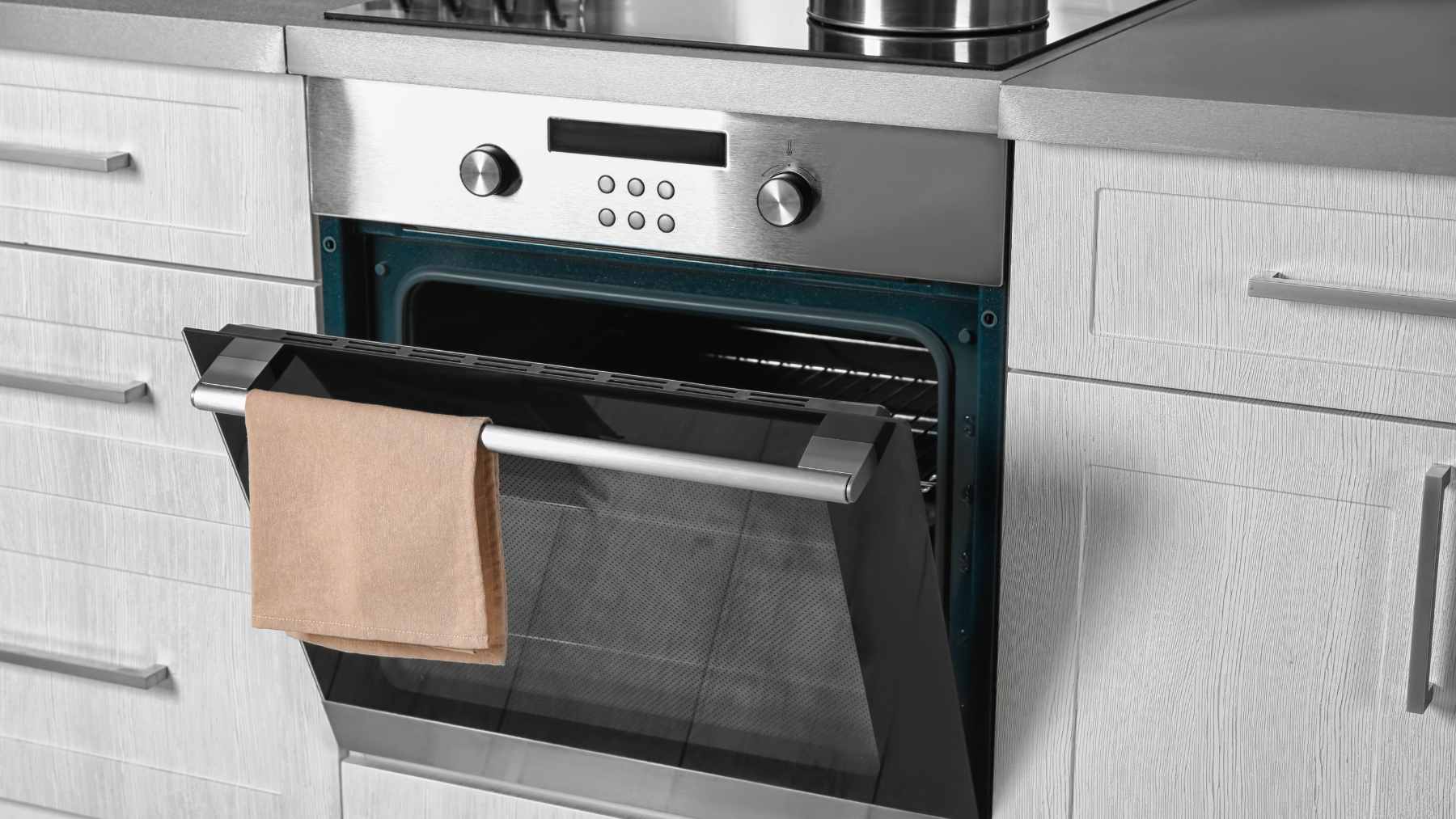 A close-up of an illuminated electric oven interior with heating elements glowing red, representing high wattage energy consumption.