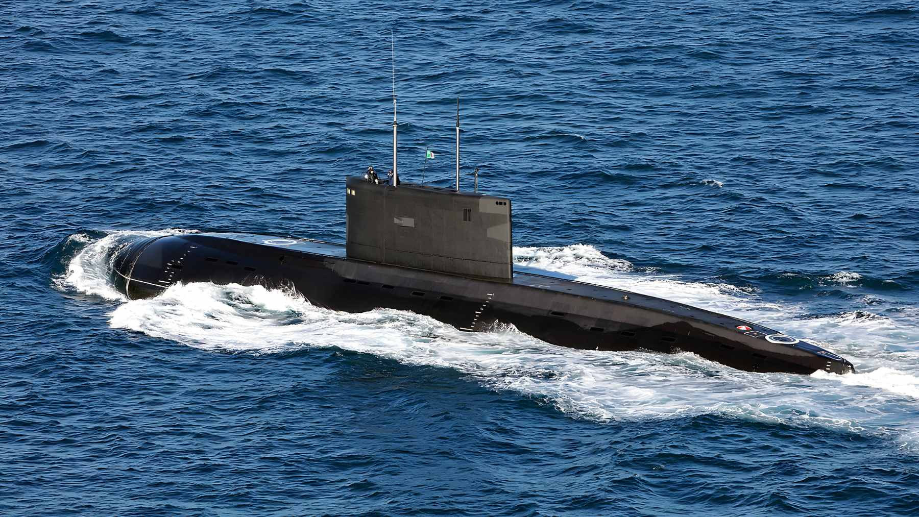 An overhead satellite view of the Bandar Abbas naval base showing a Russian-built Kilo-class submarine returned to its pier alongside several Ghadir-class mini submarines.
