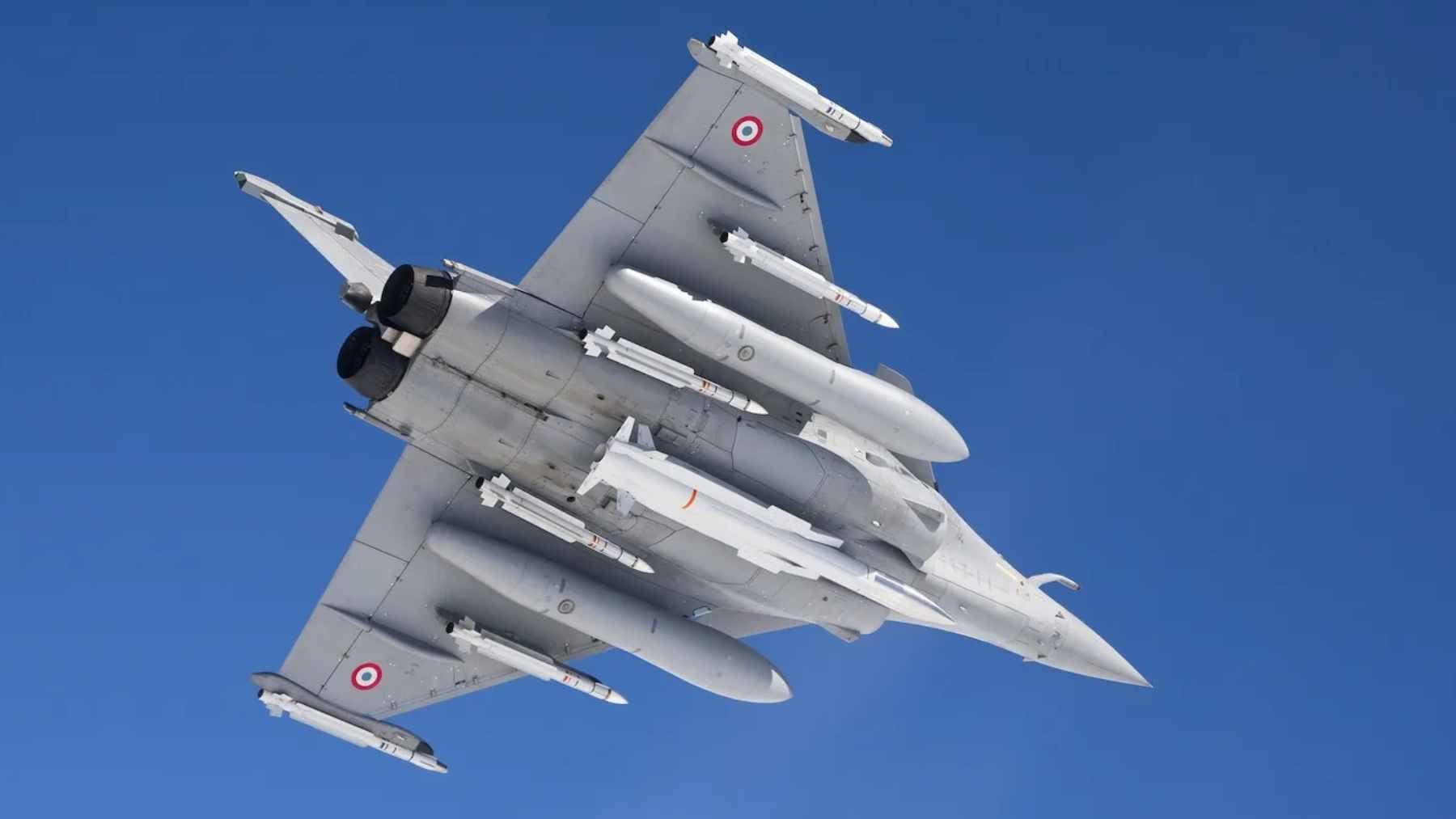 President Emmanuel Macron delivering a speech at the Île Longue nuclear submarine base, flanked by naval personnel and strategic military assets.