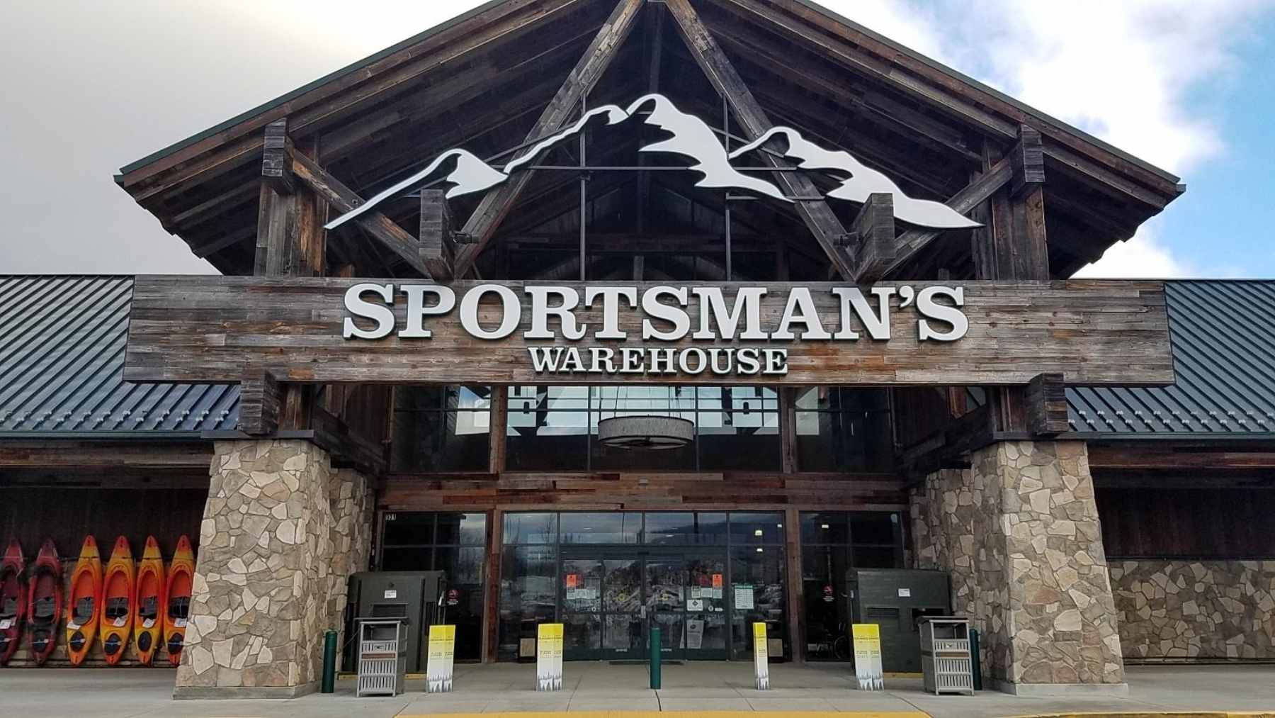 The exterior storefront of a Sportsman's Warehouse retail location with customers walking toward the entrance.