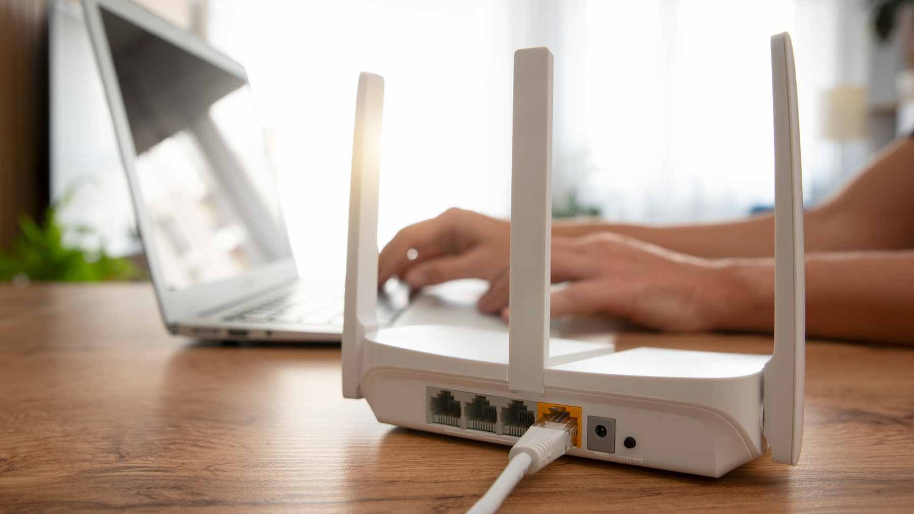 An older Android smartphone plugged into a wall charger, acting as a Wi-Fi repeater to extend a home wireless network signal.