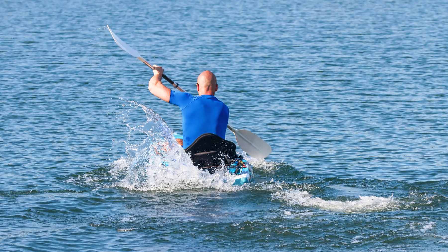 A kayaker paddling on a calm Oregon river, representing the type of small craft now required to carry a Waterway Access Permit.