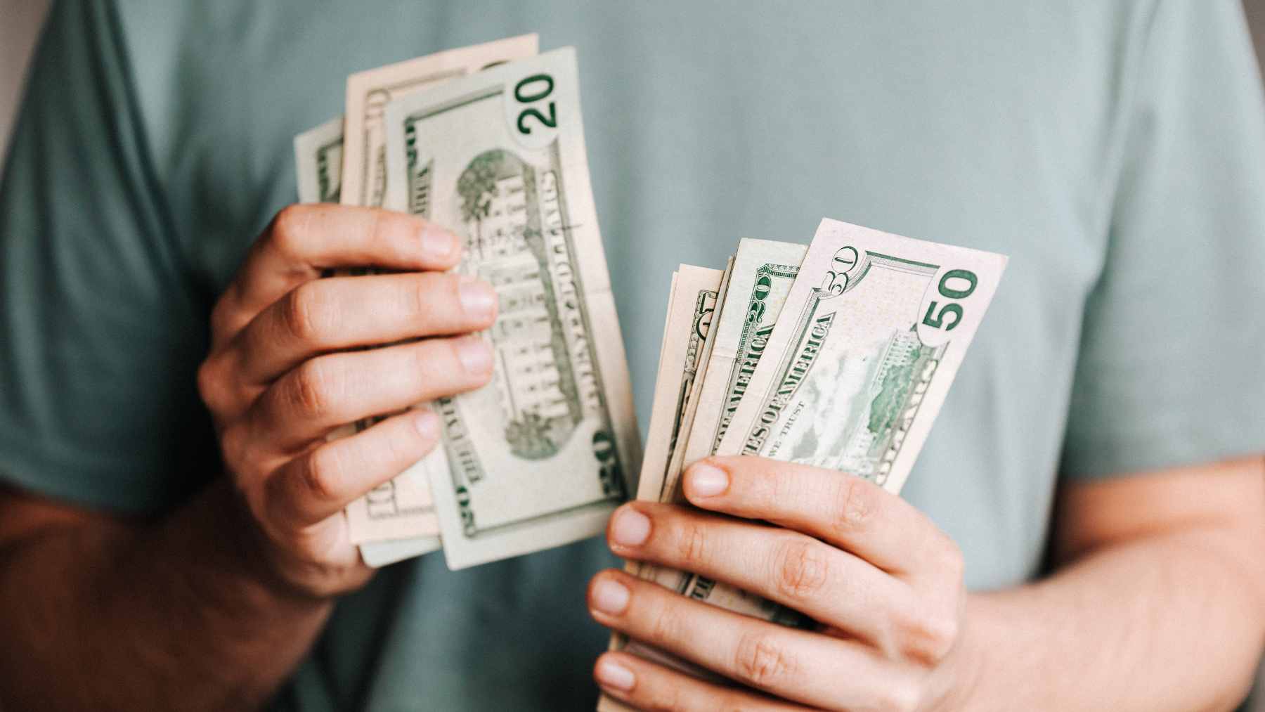 An older man sitting alone in his truck in a driveway, looking reflective and uncertain.