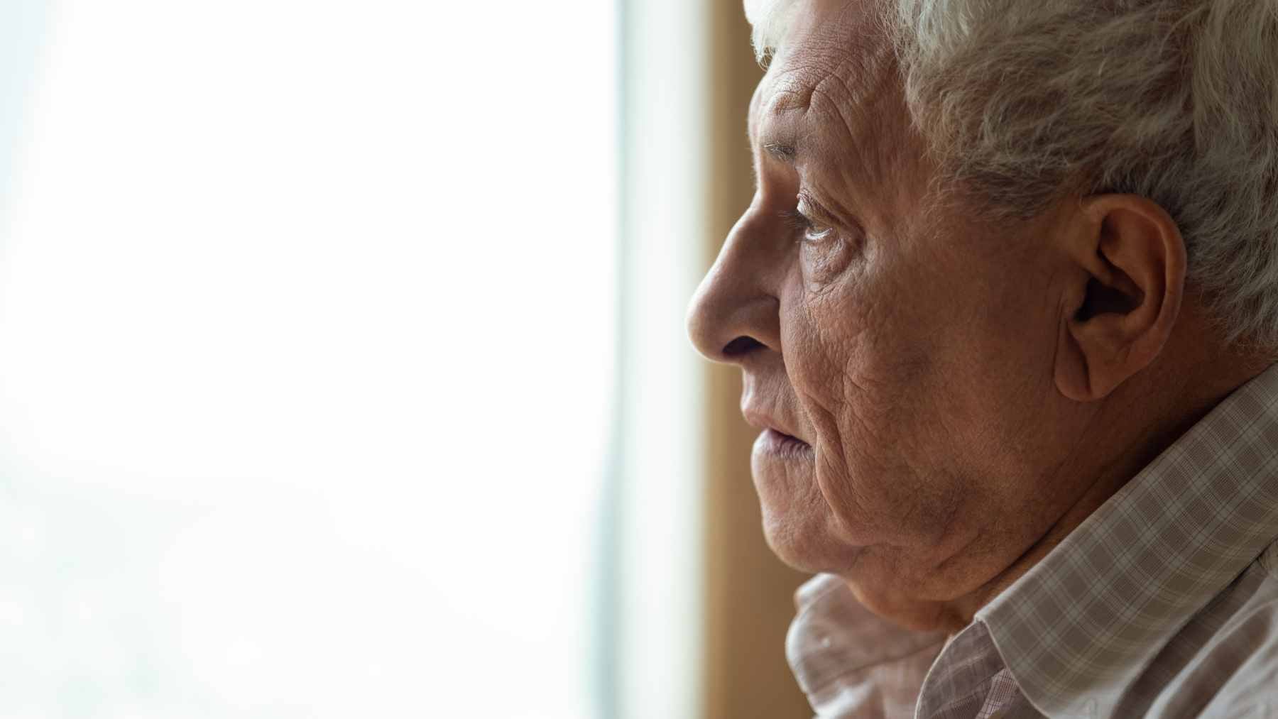 A retired man sitting alone in a quiet living room, reflecting on the transition from a busy career to a sedentary lifestyle.