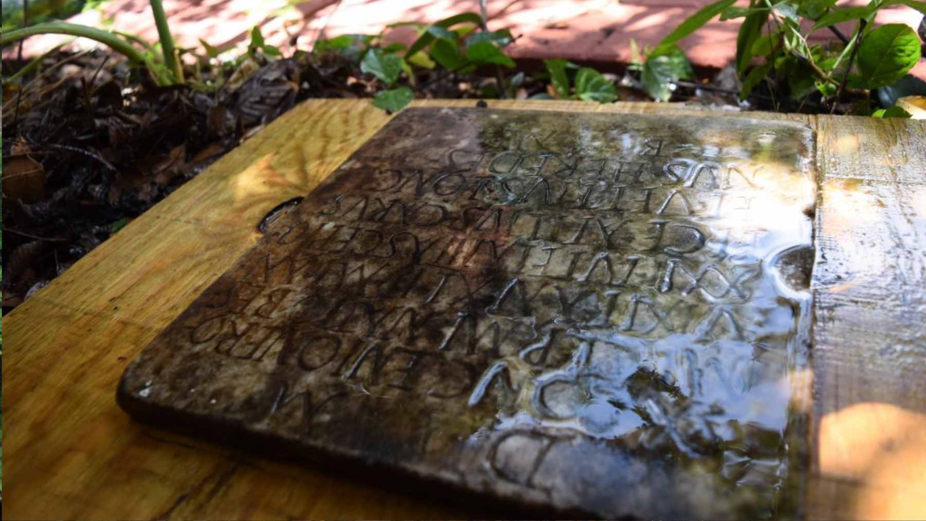 A close-up of a marble Roman funerary tablet with Latin inscriptions found in a New Orleans backyard.