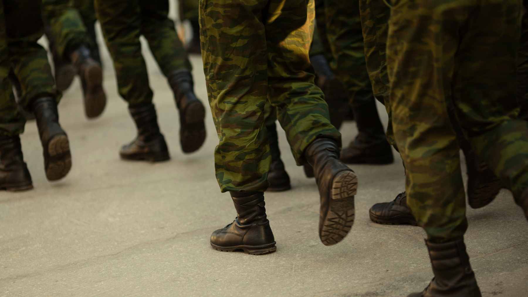 A Russian soldier wearing an experimental white "Penguin" thermal camouflage suit in a snowy field in Ukraine.