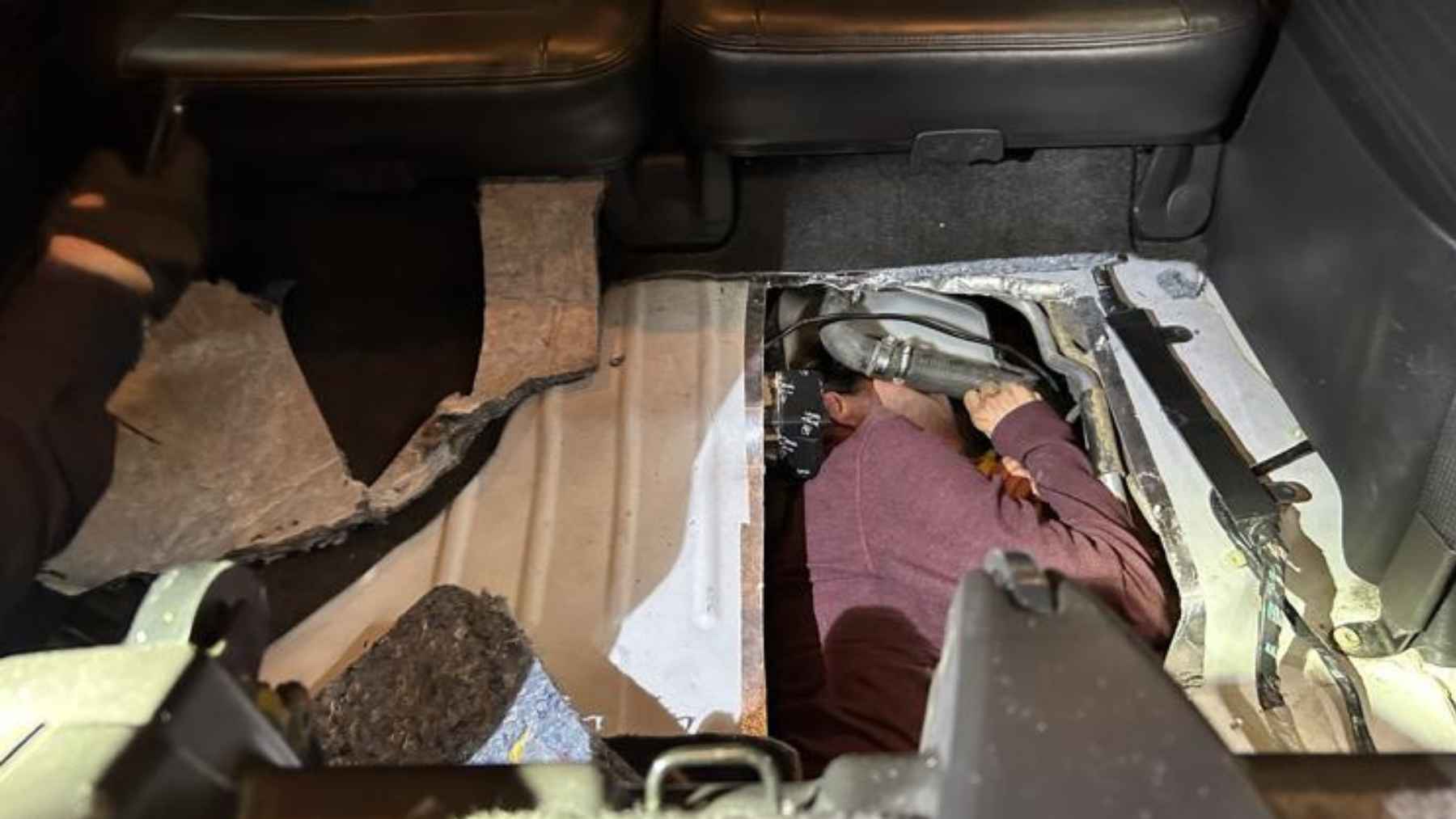 Officers inspect a hidden compartment built into a vehicle’s gas tank area at the San Ysidro Port of Entry, where a concealed person was discovered