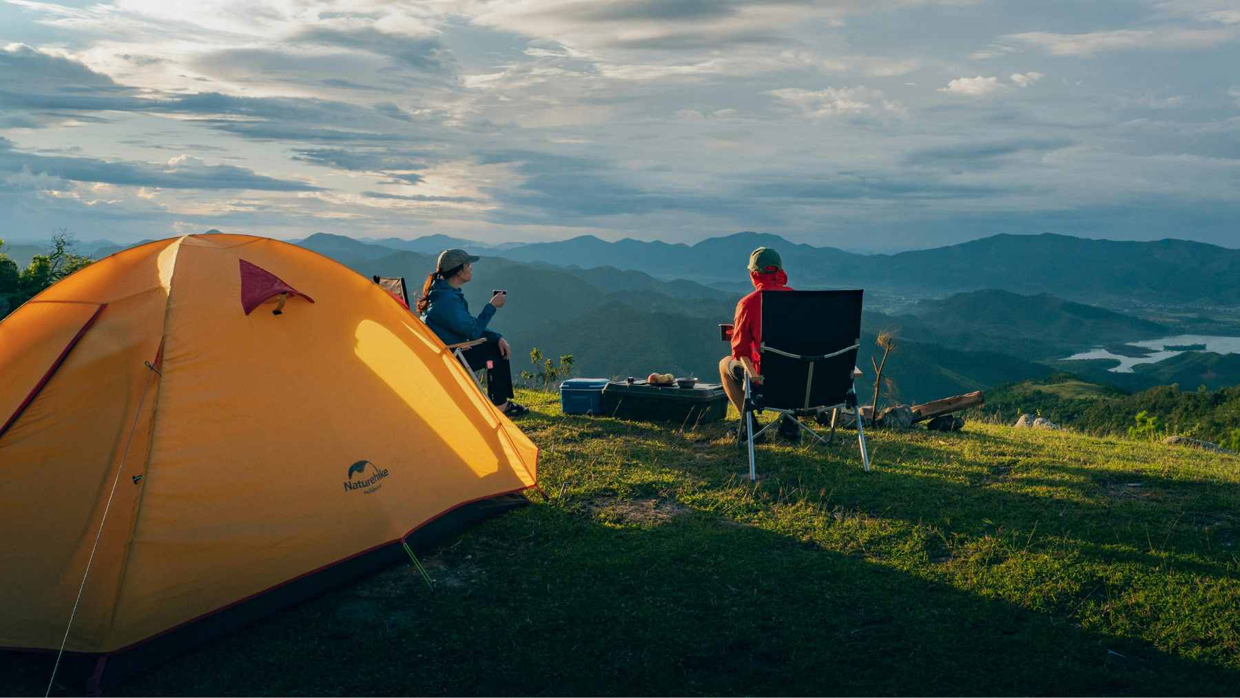 The Shine 2.0 portable wind turbine deployed on its ground mount in a coastal setting, with its three blades spinning to generate power.