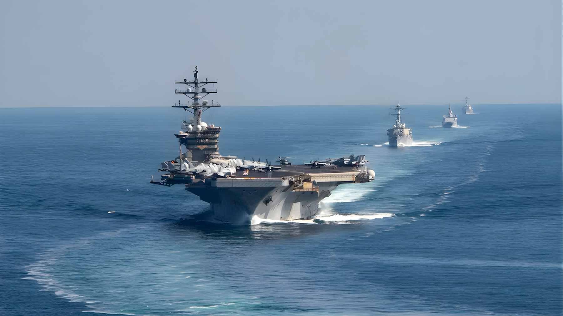 A commercial oil tanker navigating the narrow shipping lanes of the Strait of Hormuz under maritime surveillance.