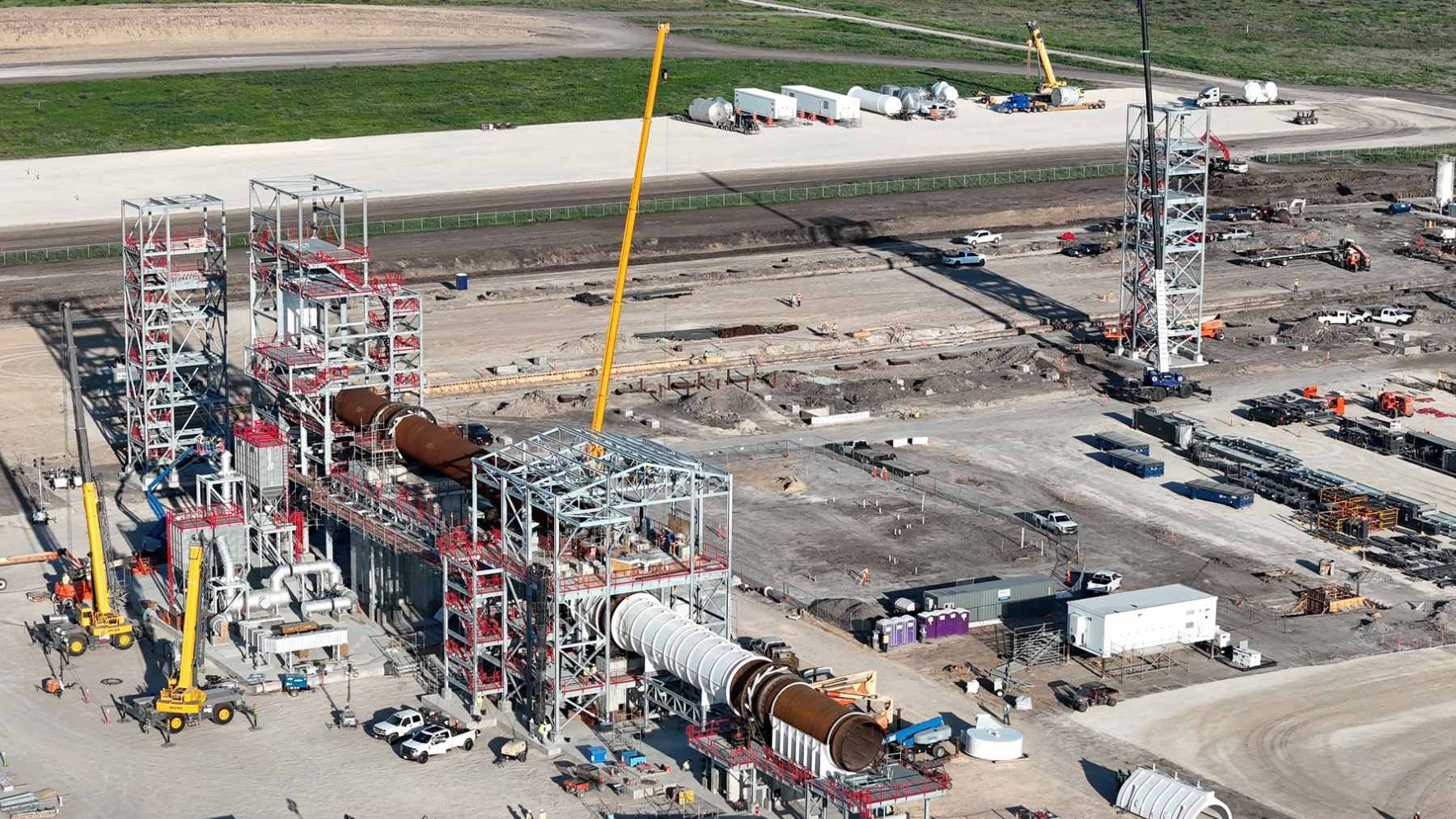An industrial drainage pipe discharging dark wastewater into a roadside ditch near the Tesla lithium refinery in Robstown, Texas.
