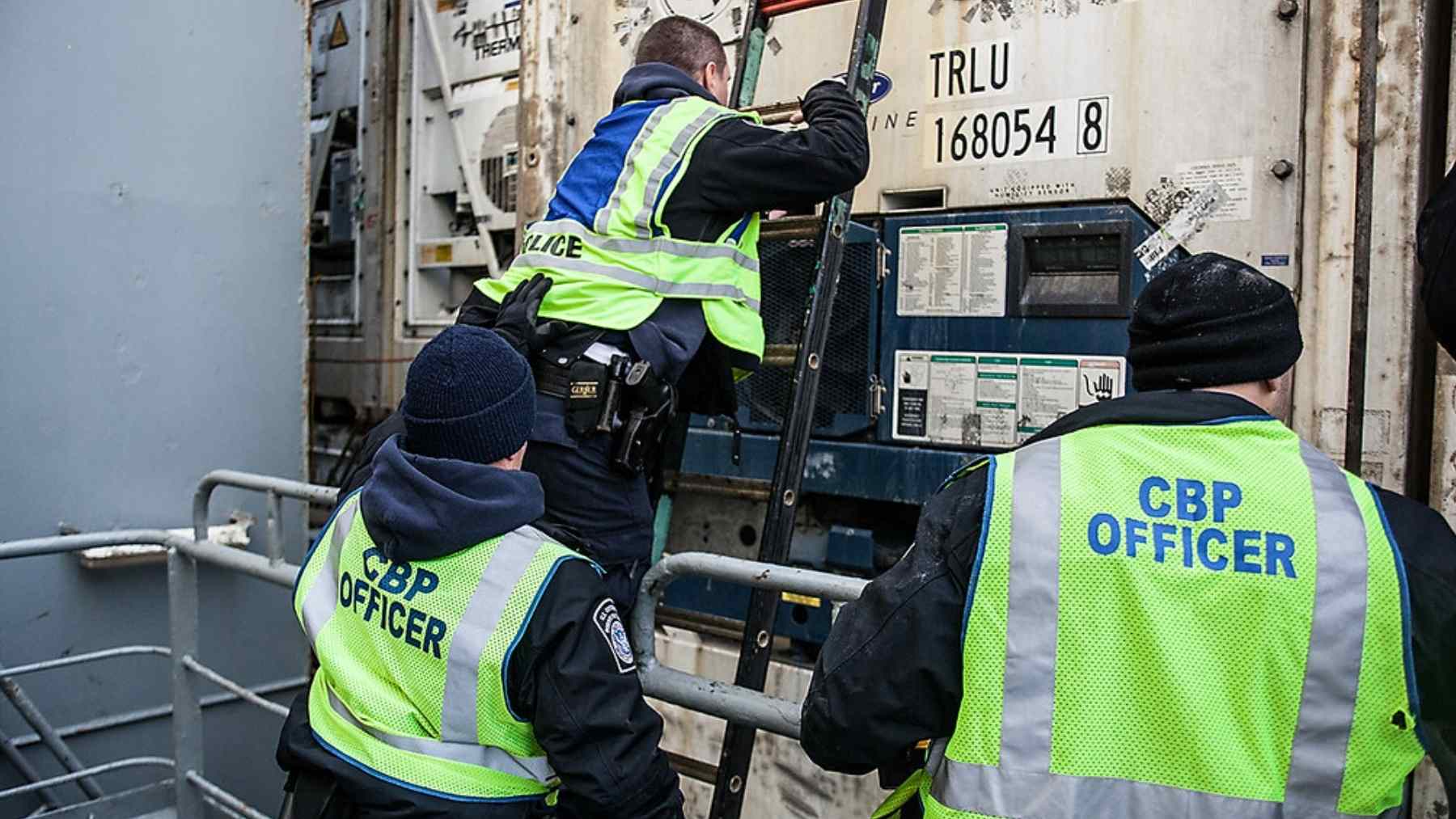 CBP officers inspect a shipping container at a U.S. port as higher tariffs drive customs bond shortfalls and cargo holds.