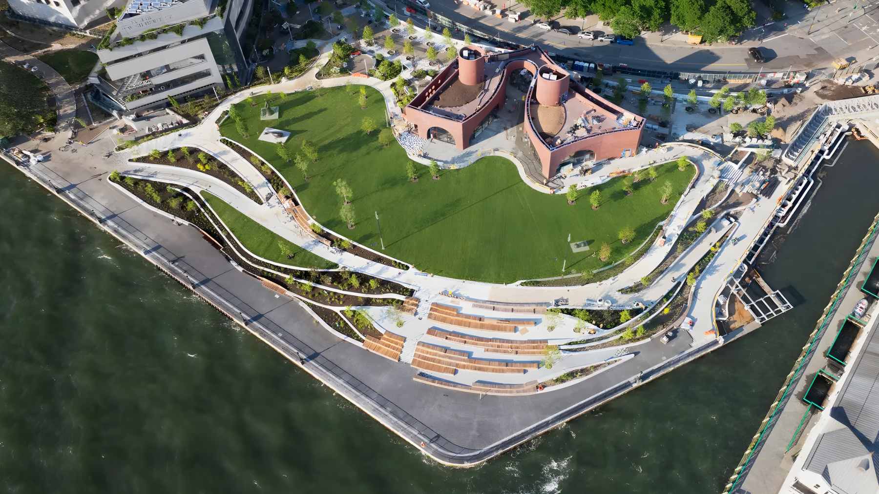 Interior of The Classroom at Wagner Park Pavilion in Battery Park City, featuring floor-to-ceiling windows with views of the New York Harbor and Statue of Liberty.