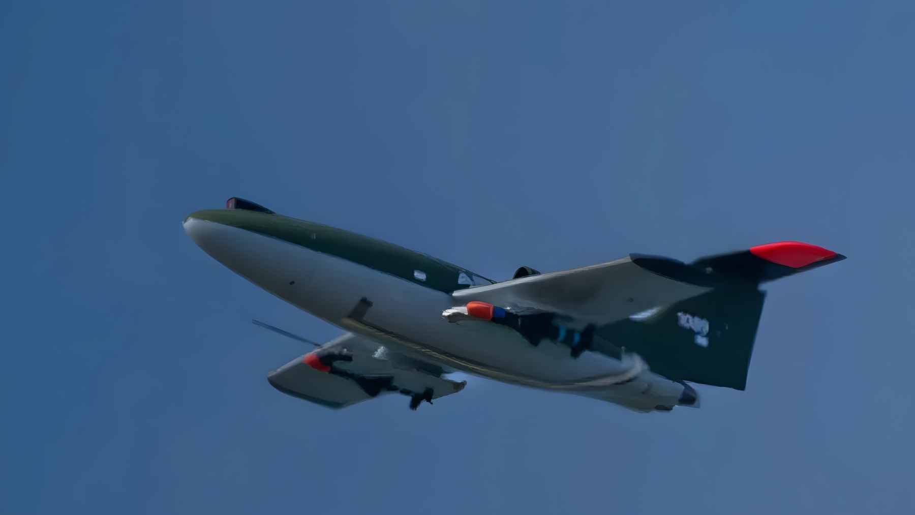 An Airbus Bird of Prey uncrewed interceptor drone in mid-flight carrying small Mark I anti-air missiles under its wings.