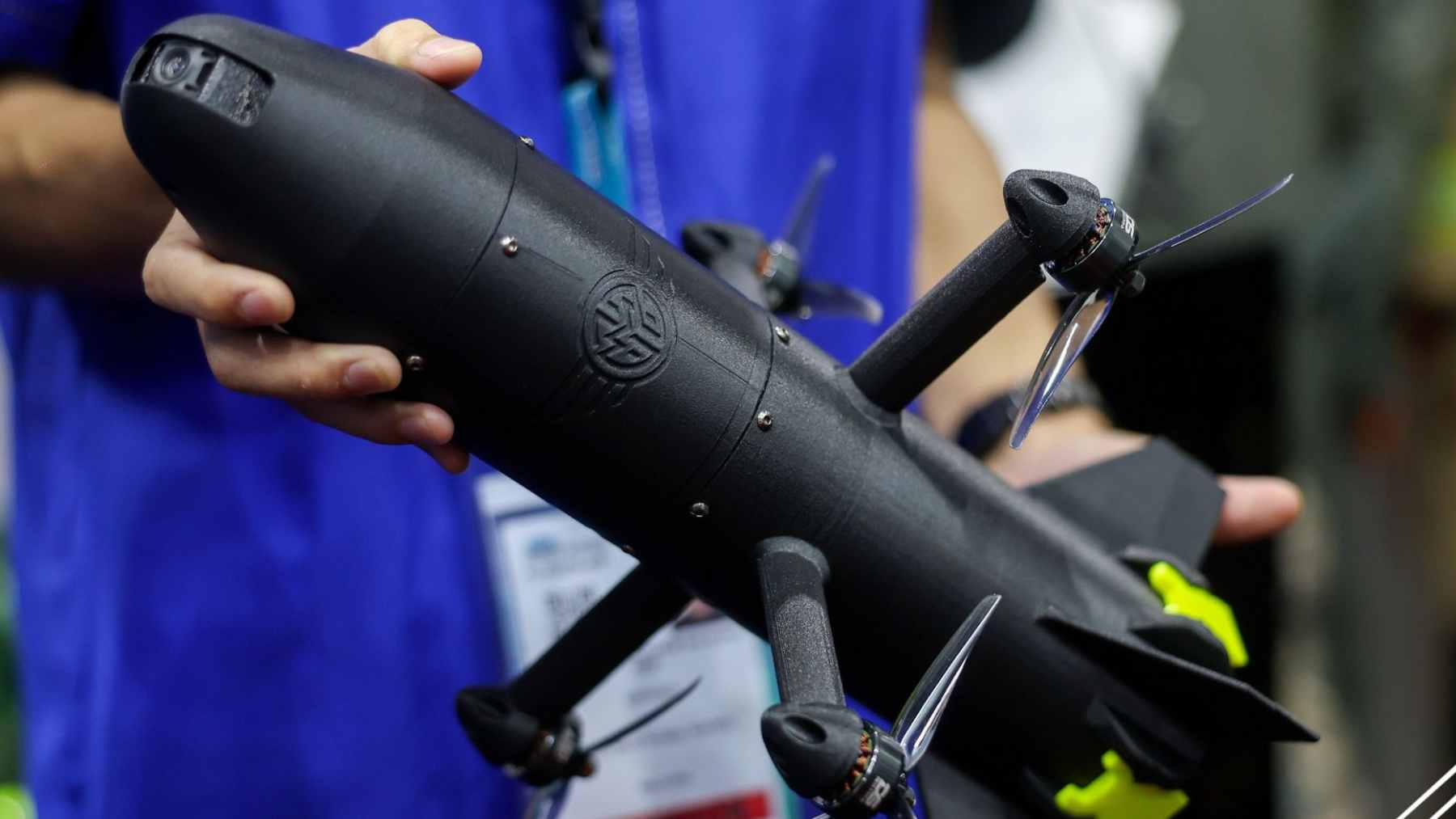 A sleek, lightweight "Ghost" interceptor drone displayed on a stand at a defense technology exhibition.