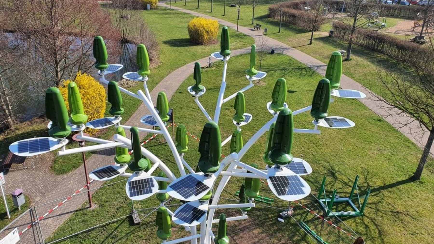A 33-foot steel wind tree structure featuring 36 green, leaf-shaped microturbines installed in a residential backyard.