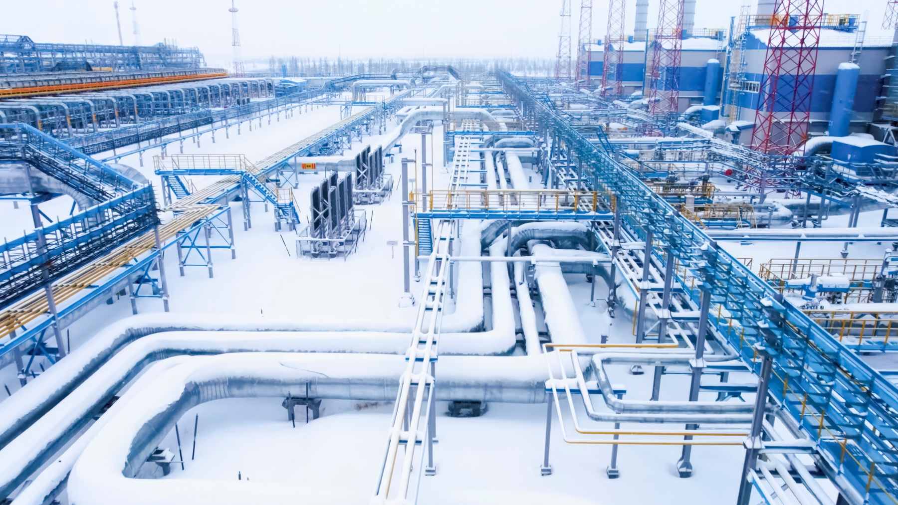 A large-scale natural gas compressor station with complex piping, representing the trans-border energy infrastructure between Hungary and Ukraine.